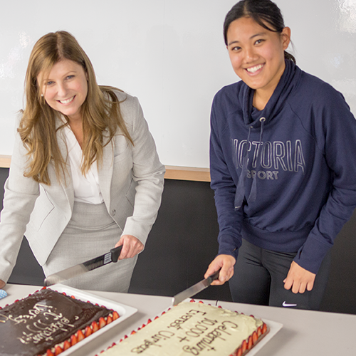 Professor Julie Cogin and students cut the cake