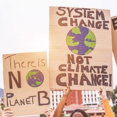 Climate change protest posters being held up.