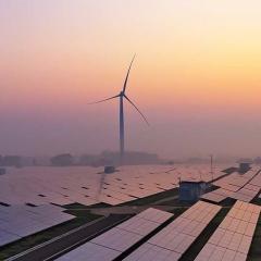 wind turbine and solar panel farm at dawn
