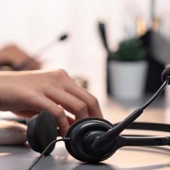 Hand on desk with customer service headset 