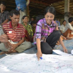 woman discussing figures on a large piece of paper