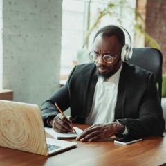 older student at laptop with headphones on
