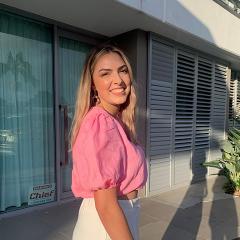 Nicole Petzer standing outside a house in a pink shirt