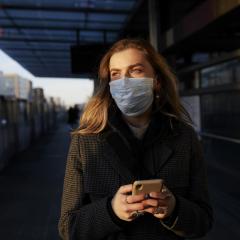 Woman at a train station with mask during COVID-19