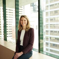 Camilla Roberts sitting on a window overlooking Brisbane city 