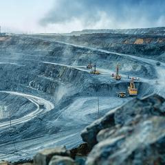 Work of trucks and the excavator in an open pit