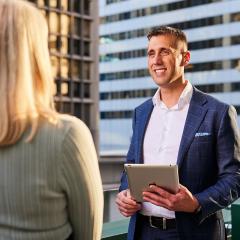 man with text book talking to woman