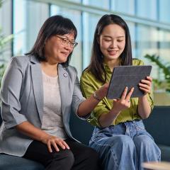 PhD student and supervisor looking at a tablet.