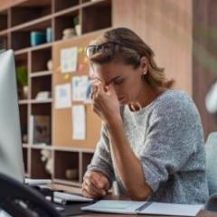 lady sitting Infront of computer looking stressed